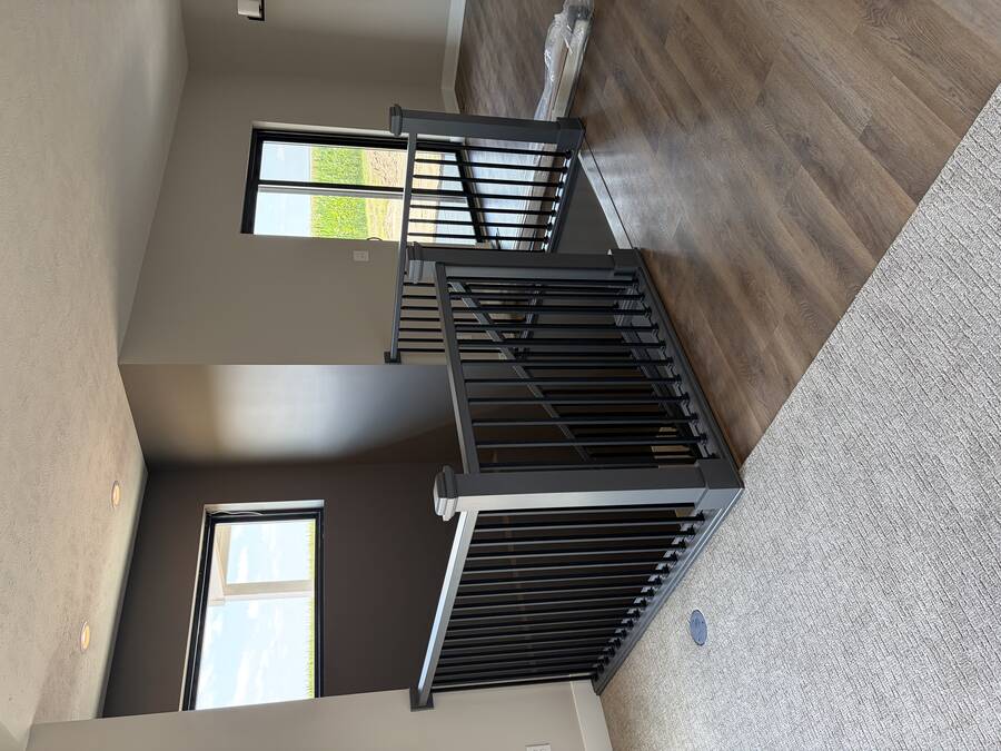 Freshly painted entryway with dark trim, black double doors, and warm foyer lighting