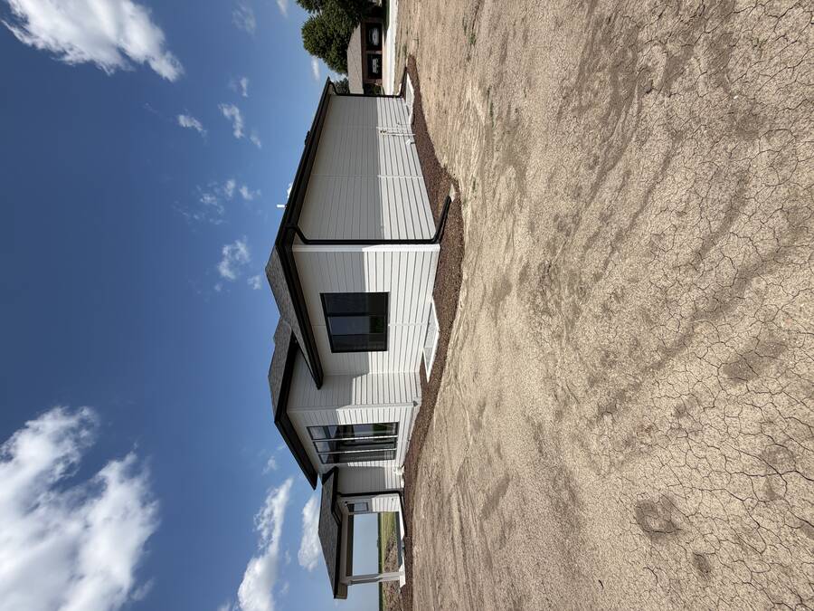 Newly painted gray and white lap siding on the rear of a new-construction home